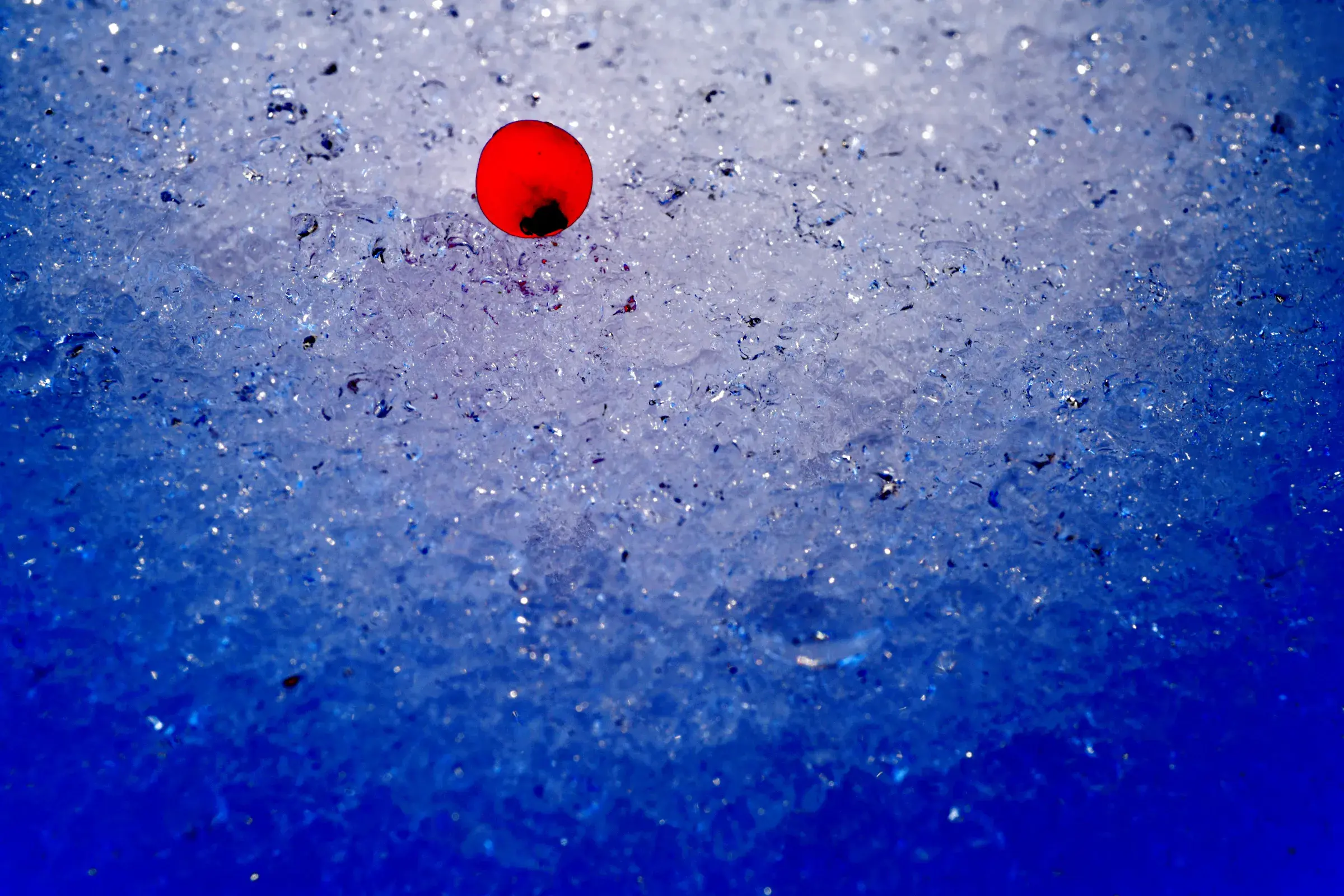 abstract blue crystalline surface, frost-like texture, a single red mark at the top
