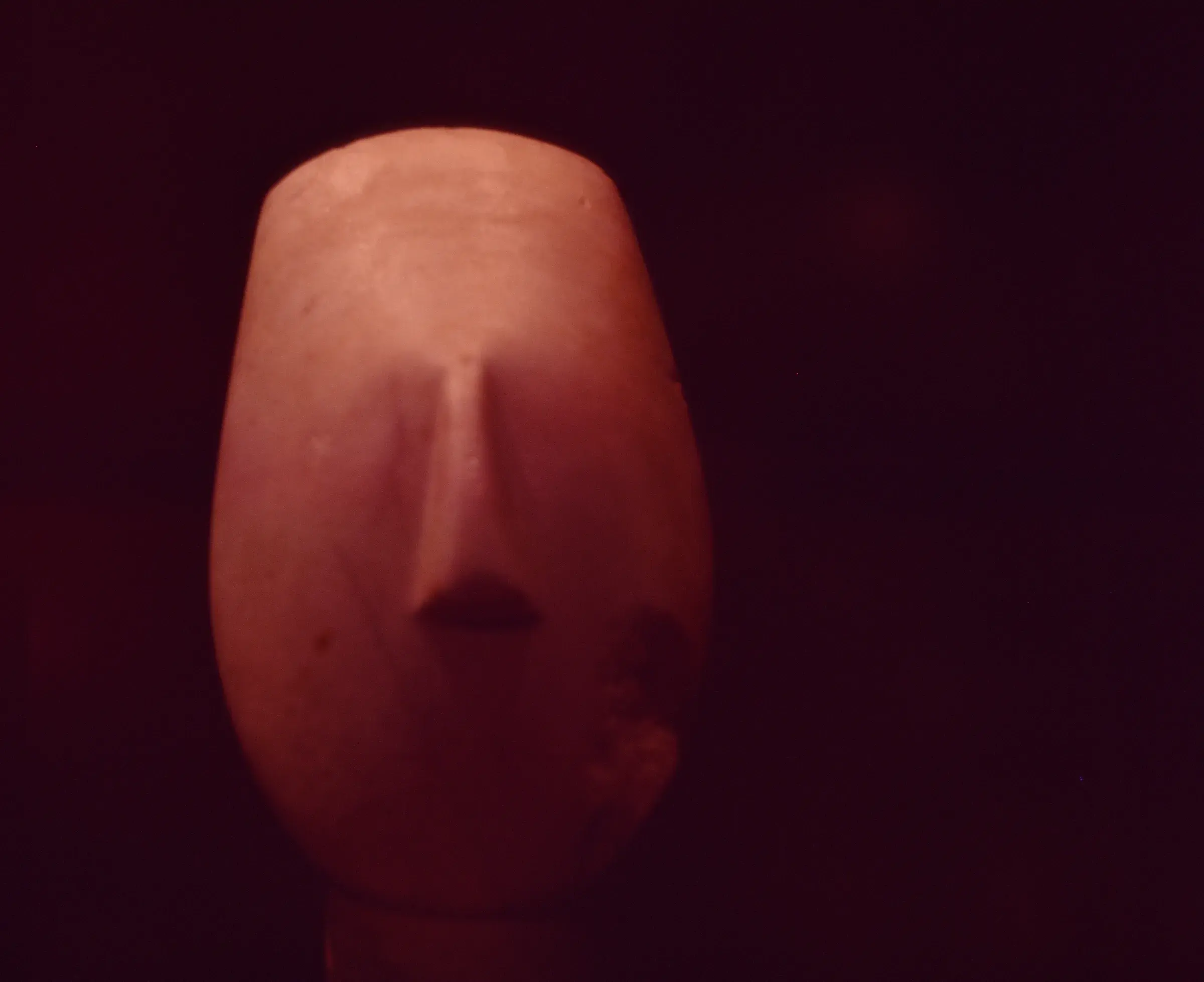 extreme close-up of a face in red light, nose and lips, everything else dark